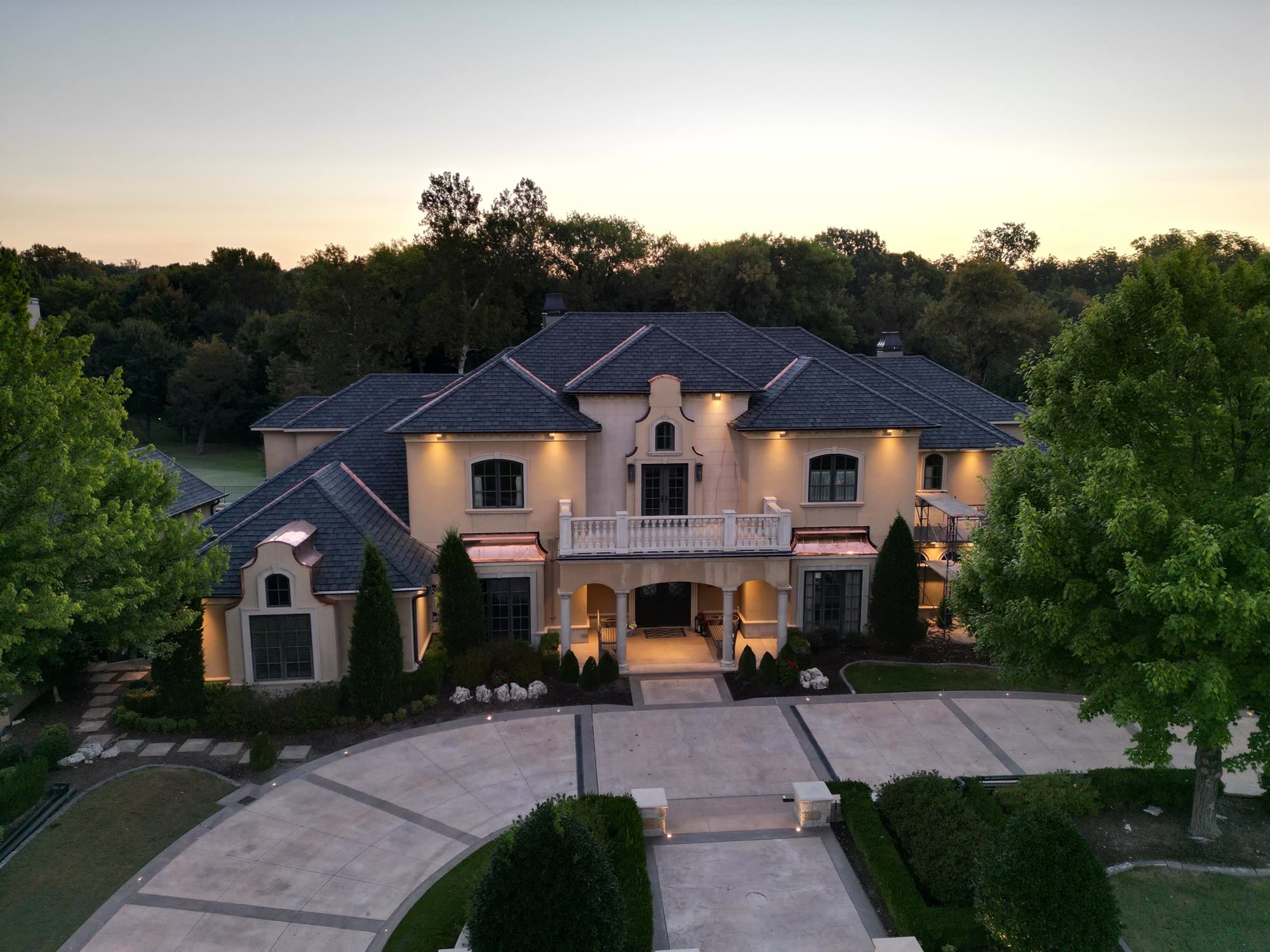RainTech Roofing slate roof with copper accents on a Tulsa home at dusk