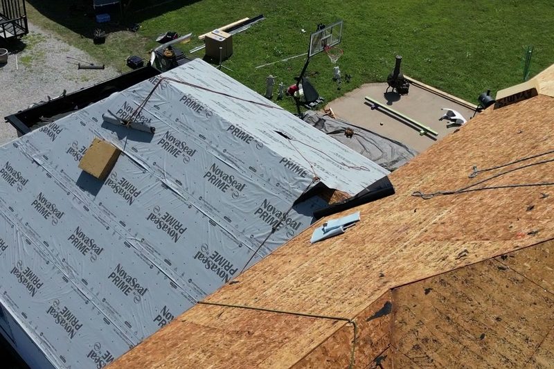 Aerial view of a roof replacement in progress with new decking and underlayment