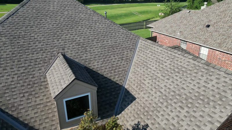 Drone view of a finished architectural shingle roof with a dormer on a brick home in a Broken Arrow-area neighborhood