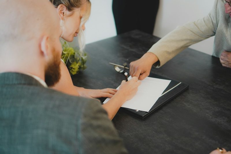 Homeowners signing a contract at a table