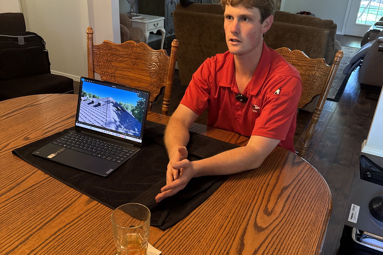 A RainTech Roofing consultant reviewing roof photos and options with homeowners at their kitchen table