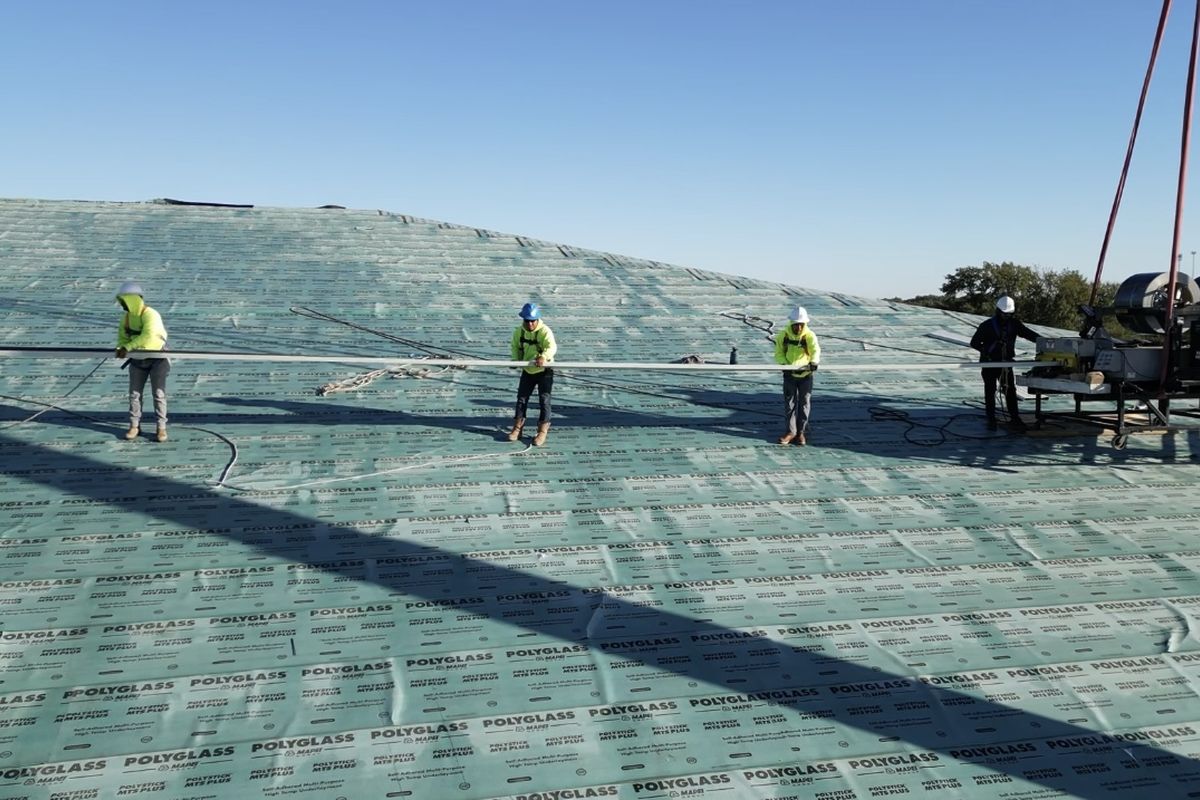 Crew rolling underlayment on a large build